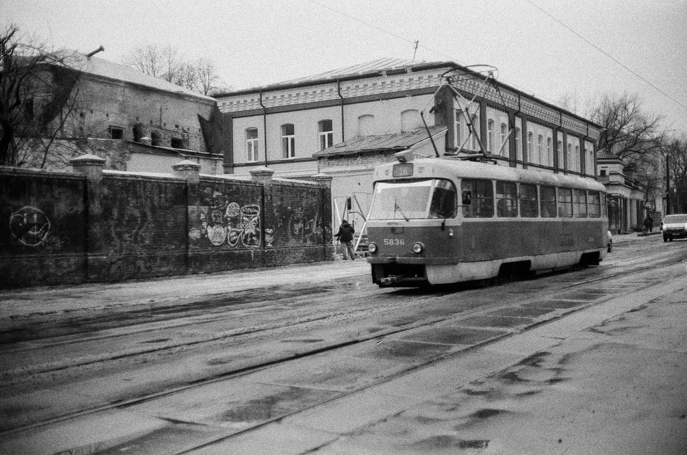 Чорно-біле фото трамвая на міській вулиці біля старого будинку